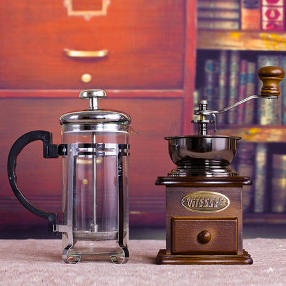 Coffee grinder and French press set displayed on a table, highlighting the artisan quality and traditional brewing method.