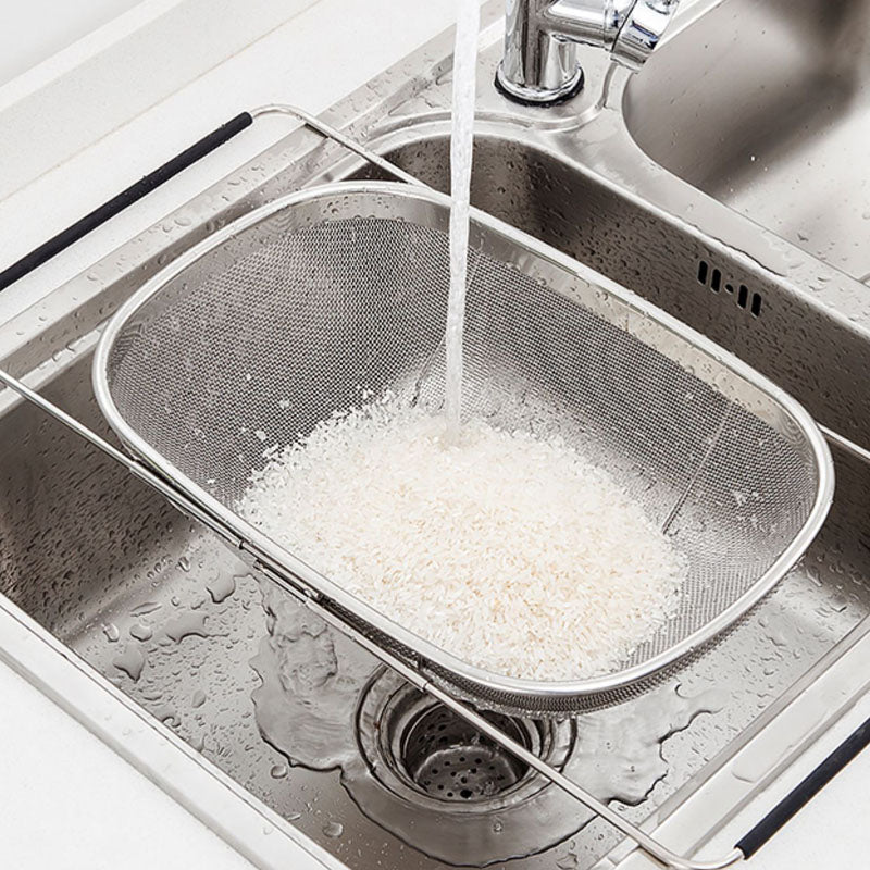 Over-sink stainless steel drain rack in use with rice being rinsed in a kitchen sink.