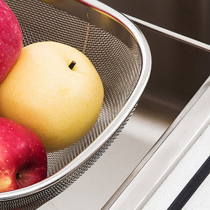 over-sink stainless steel drain rack holding red and yellow apples above a kitchen sink