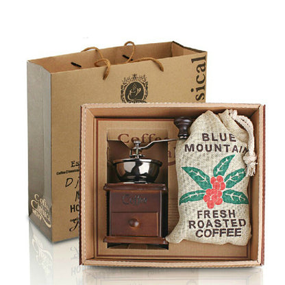 Coffee grinder and French press set featuring a hand grinder and fresh roasted coffee bag in a stylish box.