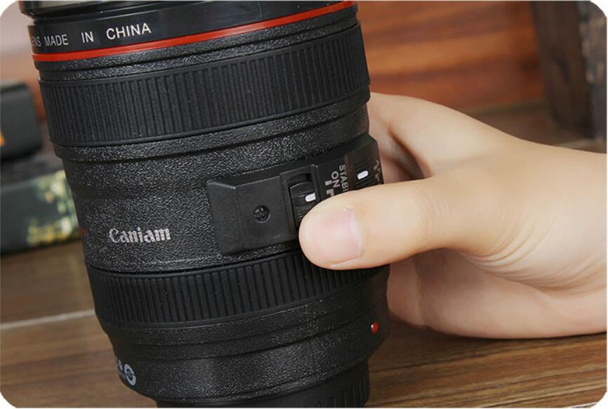 camera lens self stirring mug with a hand adjusting the switch, showcasing its unique design and functionality.